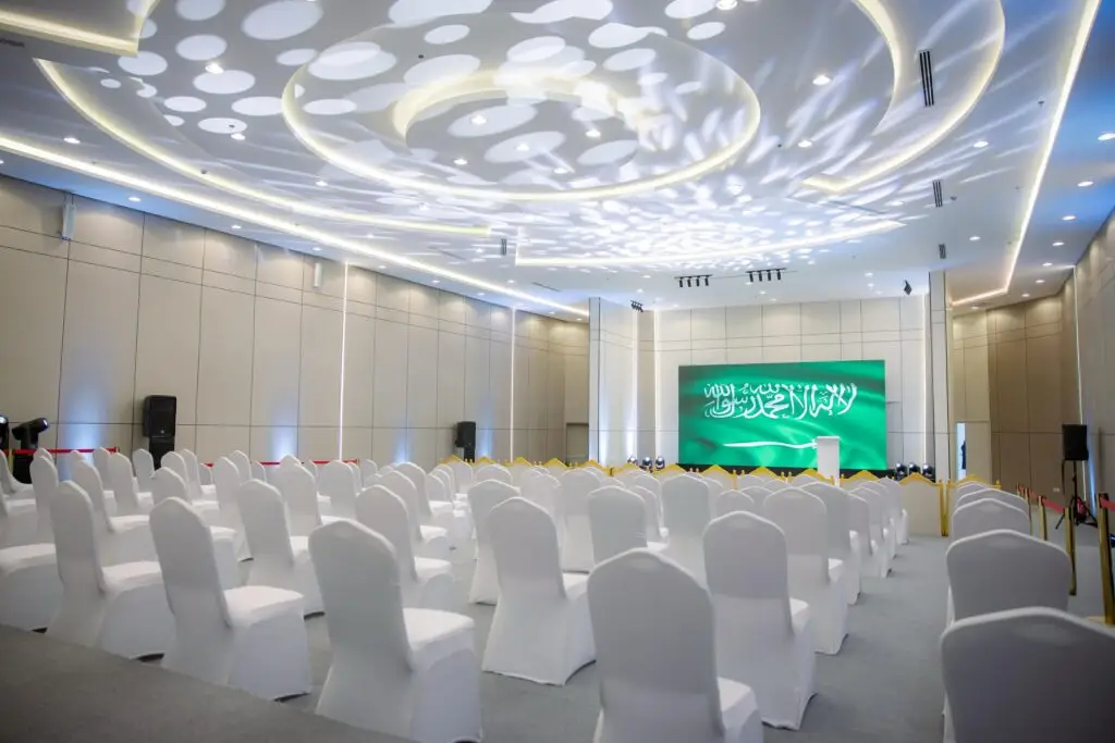 قاعة مؤتمرات مؤتمرات باربارس بكراسٍ باللون الأسود وشاشة عرض مسرحية سوداء تعرض نصًا كبيرًا باللغة العربية حول "التوعية". مصممة لتصاميم الإضاءة الدائرية. أردفة سريعة وخالية من الحضور، ويلاحظ الطباخ الرسمي للمكان والذي يسمح مع جامعة القصيم، حيث يحدث في بعض الرجال شماغ سعودي أو يغترة ويقال وبشت سعودي.