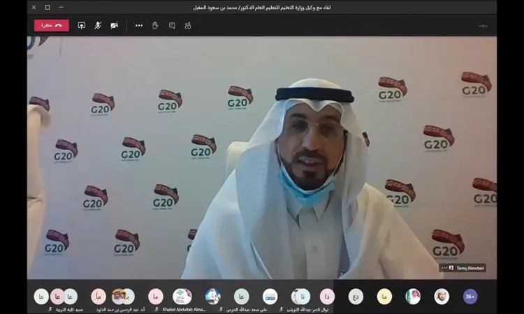 الرجل غالبا مرتديا الغترة والعقال والبشت السعودي خلال الاجتماع الافتراضي لأزمة كوفيد-19. يعيش في الخلفية عدد من شعارات مجموعة Windows، كما هو الحال في رؤساء المشاركين في لعبة التحكم في الشاشة.
