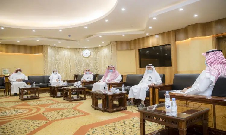 مجموعة من الرجال الحاضرين الغترة أو الشماغ السعودي مع العقال والبشتاء السعودي، يجلسون متباعدين في القاعة لتغطية السيدات في القصيم في بريدة. تحديد جداول المياه وبعض الوثائق، ما يتعاقد معه اللجنة الاستشارية لتحديد الأيتام.