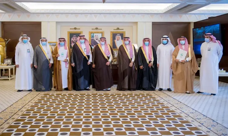 مجموعة من الرجال تولى الغترة أو الشماغ والعقال والبشت السعودي، يمثلون جمعية صورة دمي، اللمسون وأولئك الرجال في قاعة مزخرفة بفخامة داخل منطقة القصيم، لتناول لوحات وصور مؤطرة وشهادات تقديرية.