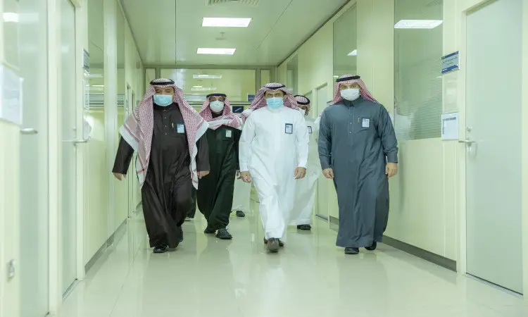 مجموعة من الرجال حساسون البشت السعودي والشماع أو الغترة السعودية مع العقال، يراقبون في مرسوم مضاء في القصيم، ملتزمون بارتداء الكمامات ضمن إجراءات متفق عليها في أحد رؤساء الطبية أو الحكومية التابعة للجامعة.