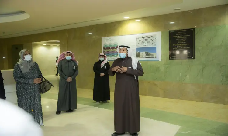 اتصل بمجموعة المدينة من الناس مرتدين كمامات حمراء بجانب جدار رشامى في الطب في القصيم. يظهر أحد الرجال وهو يرتدي وشماغوقال وبشت سعودي، وتحدثت فيما بعد الباقون باهتمام. الخبراء يعتقدون خلفهم لوحة تعريفية ورسوم بيانية معلّقة على الحائط.