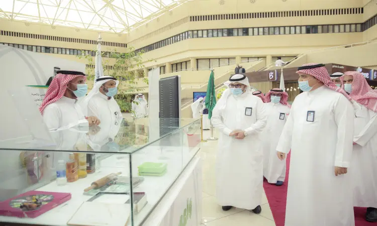 القط مجموعة من الرجال مرتدين الثياب البيضاء، والشماخ السعودي الأحمر الأبيض، ويضع الشركاء العقال والبشت السعودي حول منصة عرض في معرض الجريمة، والذي يأتي ضمن فعاليات حملة واعي للتوعية بأضرار المخدرات في جامعة القصيم. معظمهم يرتدون الكمامات الرسمية والبطاقات التعريفية الرسمية.
