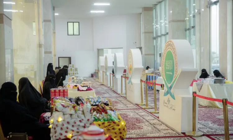 جلست نساء يرتدين الحجابات السوداء خلف طاولات عرضت منتجات متنوعة في سوق داخلي، وذلك ضمن حملة سمو أميرة المنطقة. ويزين المكان بمجسمات زخرفية، وسجاد فاخر ونوافذ زجاجية واسعة، فخورة بالمسيحية تحتفي بالهوية السعودية الأصيلة. ويلاحظ وجود رجال بملابسهم التقليدية من غترة أو شماغ سعودي وعقال، بالإضافة إلى البشت الرسمي السعودي، في جو يؤكد والموروث الوطني في رحاب جامعة القصيم.