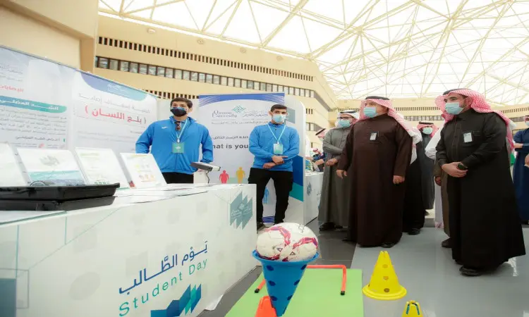 تجمّع مجموعة من الأشخاص، أصلهم الغترة أو الشماغ السعودي مع العقال والبشت السعودي، حول جناح في فعالية يوم الطالب في القصيم. وقد تتميز الصين بملصقات جماعية للأندية، بالإضافة إلى طاولة تحتوي على مواد ومعدات رياضية.