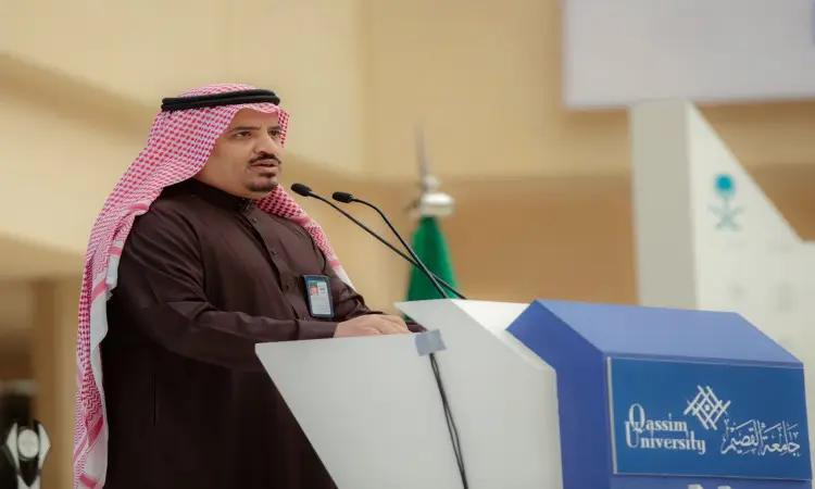 اتصل رئيس الجامعة مرتديًا غترة سعودية وقالًا وبشتًا سعوديًا، مشهورًا من منصة تحمل شعار جامعة القصيم. تتوزع أمام الهيئات، بينما تقف خلف راية المملكة العربية السعودية ونادي الأندية الرياضية.