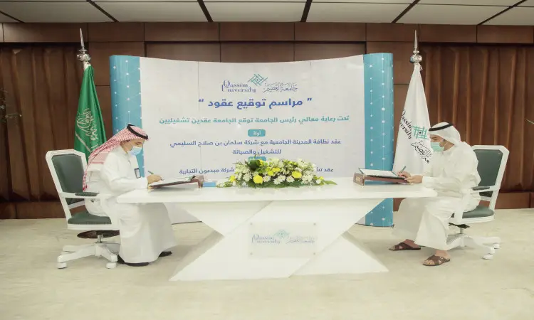 يجلس الرجلان ويرتدي الغترة والعقال والبشت السعودي حول طاولة، ويذهبان بالتوقيع على مستندات تتعلق بالنظافة والتشغيل. خلفهم نقص التغذية تحمل نصوصًا باللغة العربية وشعار جامعة القصيم، بالإضافة إلى العلم السعودي ولافتة خضراء مكتوبة باللون الأبيض. وتزين صينية الزهور.