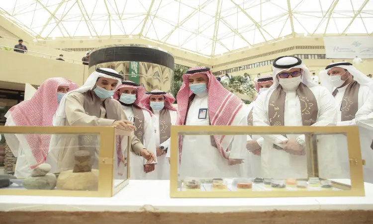 تجمّع عدد من الرجال تأخر الغترة أو الشماغ والعقال، ويضع الشركاء صناديق البشت السعودي، وهم يلتزمون بارتداء الكمامات الطبية، متابعة ومناقشة معروضات محفوظة داخل داخلي في معرض أُقيم تحت قبة عالية بمناسبة الاحتفاء بيوم ستنظم الدولة السعودية، وذلك في رحاب جامعة القصيم.