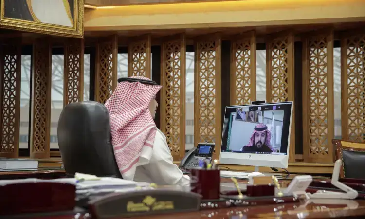 يرتدي رجل يرتدي الزي السعودي الرسمي، متمثلاً في الغترة السعودية مثبتة بالعقال والبشت السعودي، إلى مكتبه فخمات خشبية. يشارك عبر الاتصال المرئي مع شخصية أخرى خارج الشماغ والعقال والبشتوات، حيث يتحكم الآخرون بالنقاش الرسمي ربما حول مهارات اللغة العربية في جامعة القصيم أو التخطيط للمؤتمر الدولي القادم.