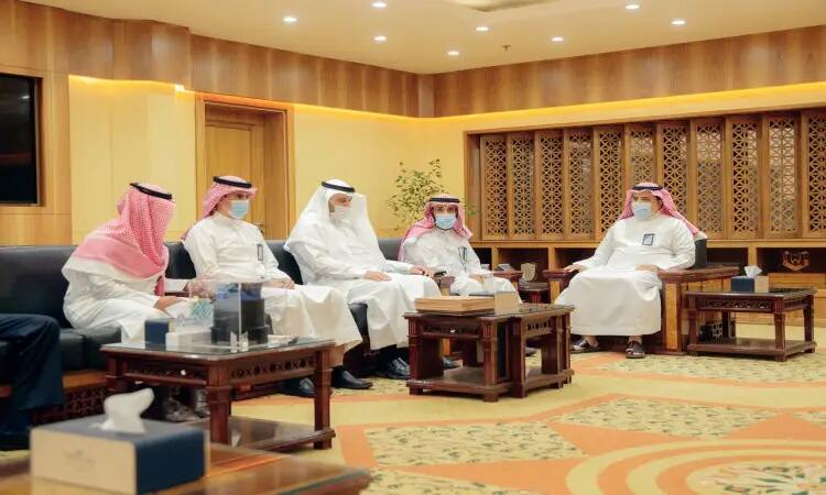 يجتمع خمسة رجال تحت الغترة أو الشماغ والعقال، ويضع الفرق البشت السعودي، في قاعة مضطرة إلى ورق مكسو بالخشب في جو يعكس بشكل رسمي والفخامة. يجلسون على الأرائك وقد ارتدوا الكمامات، ويناقشون حول تحدي الباحثين عن العمل. يضفي الديكور المزخرف و صناديق المناديل المنسقة والسجاد الفاخر لمسة من التراث والهيبة على هذا اللقاء الجامعي في القصيم.