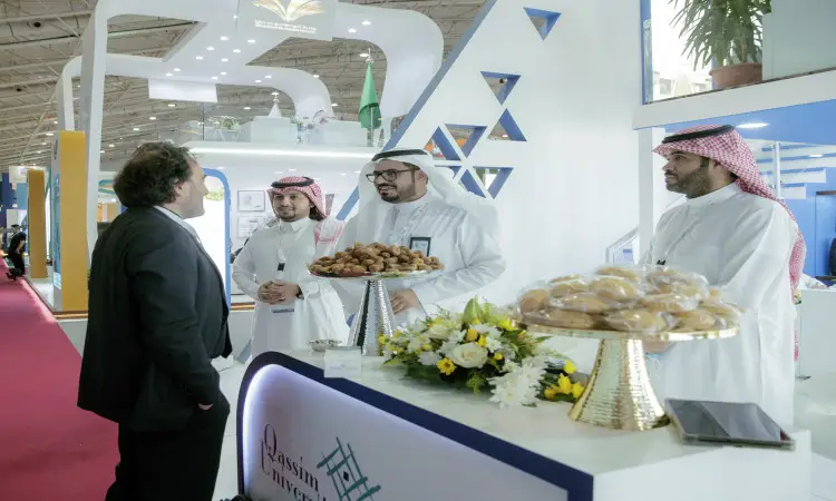 الاتصال ثلاثة رجال مرتدين الغترة أو الشماغ والعقال والبشت السعودي التقليدي، في جناح حديث يغلب عليه اللون الأبيض يؤمن ضمن فعاليات المؤتمر والمعرض الدولي للتعليم، حيث يعرضون أصنافاً من المعجنات والزهور أثناء تفاعلهم مع رجل يرتدي أزياء ويمثل الجامعة، وذلك من أجل احترام هوية جامعة القصيم.