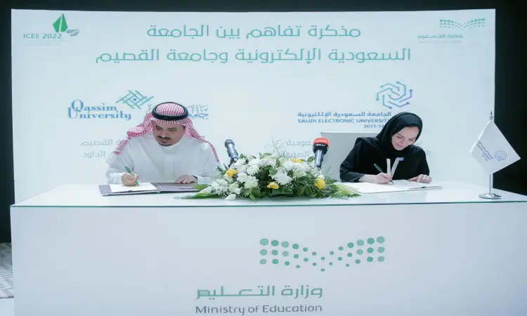 يرتدي الرجل بدلة شماغاً وبشتاً سعودياً، إلى جانب فتاة في المدرسة على طاولة توقيع الوثائق. يراعى خلفهما شعارات جامعة القصيم والسعودية الإلكترونية باللغتين العربية والإنجليزية، أثناء متوسط متوسط شعار وزارة التعليم.
