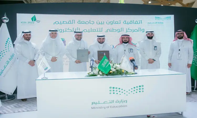 تجمع عدد من الرجال مرتدين الغترة أو الشماغ والعقال، إضافة إلى البشت السعودي والبزات الرسمية، خلف طاولة تحمل وثائق خلال مراسم التوقيع المستفيد التعاون مع وزارة التعليم، وذلك ضمن فعاليات مؤتمر المؤتمر الدولي للتعليم (ICEE 2022)، حيث تتواجد لوحات المؤتمر ووزارة التعليم في الخلفية، وترفرف الأعلام السعودية على اعتدال ويحق جامعة القصيم.