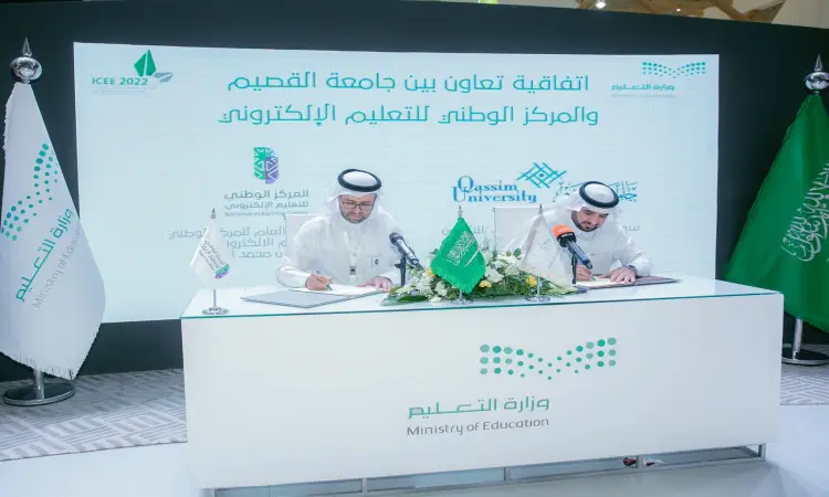توقيع رجلان يرتديان الزي السعودي الرسمي المكون من الغترة أو الشماغ، والعقال، والبشت السعودي، التعاون على طاولة أمام شعاري جامعة القصيم والمركز الوطني للتعلم الإلكتروني، وذلك خلال فعاليات المؤتمر الدولي للتعليم، وبحضور أعلام وزارة التعليم والعلم السعودي بجوارهم.
