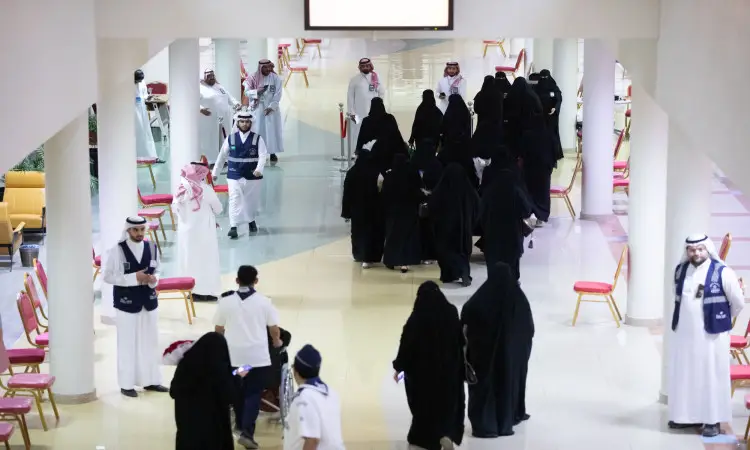 مجموعة من الرجال، من بينهم طلاب الدفعة التاسعة والتسعة من جامعة القصيم، وسيشونون في ردهة ذات أعمدة طويلة وكراسٍ حمراء من خلال إحدى فرق التحرير الرسمية. وقد ارتدى عددٌ من الرجال الزي السعودي التقليدي التوسع في الغترة أو الشماغ السعودي مع عقال وبشت سعودي، الأمر الذي أضافى على البرنامج الرسمي والاحتفالي المميز.
