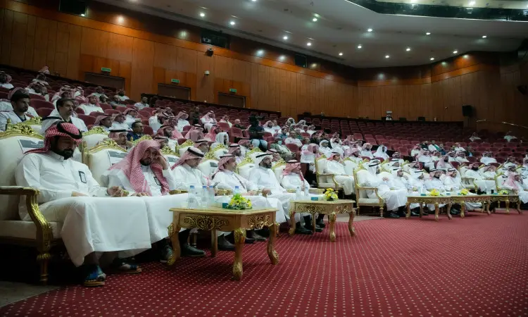يجتمع عدد كبير من الرجال وهم في انتظار الزي السعودي الرسمي المكون من الغترة أو الشماغ والعقال، بالإضافة إلى البشت السعودي، فيستعدون داخل القاعة محاضرات واسعة ذات مكسوة بالخشب وسجاد أحمر في جامعة القصيم. ويحضر المشاركون ورشة عمل حول التحول إلى الفصول الثلاثة، حيث تعقد جلسة على كراسي فخمة بالقرب من طاولات مزينة بالزهور.