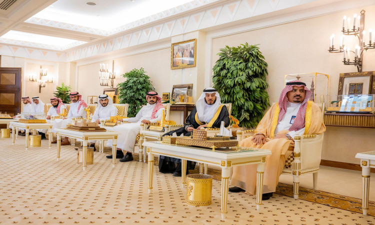 يجلس عدة رجال، من بينهم أمير القصيم، مرتدين الغترة أو الشماغ السعودي مع العقال والبشت السعودي، على كراسٍ فخمة في قاعة تزدان بفخامة و لتزيين ذهبية وديكورات راقية ولوحات مؤطرة. يسود المكان طابع رسمي وأجواء الإيمان مكانة أساسها وقيمها للجميع.
