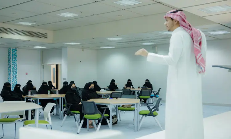 رجل اتى غترة سعودية وعقال وبشت سعودي يخاطب مجموعة من النساء واضطرن إلى ارتداء ونقاباً أسود، وذلك من خلال فعالية "يوم المهنة التقني" التي تم إنشاؤها في قاعة حديثة في القصيم، وتركزت محاورها على مجالات تقنية المعلومات والمسارات التقنية.