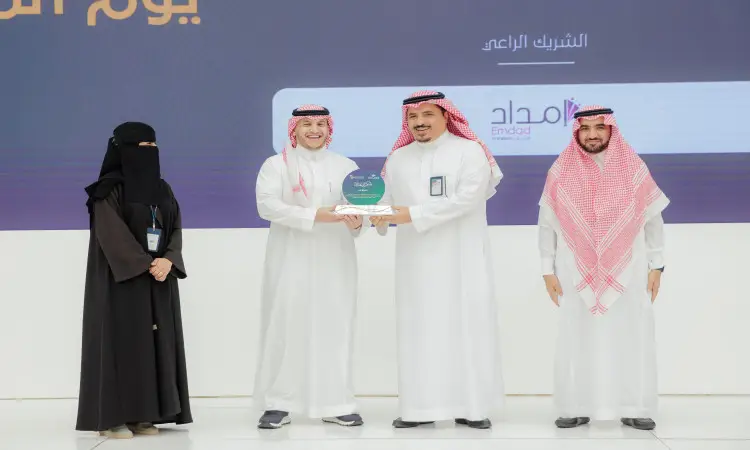 خلال التجارب المهنية الفنية، لمس أربعة أشخاص على المنصة في حفل تكريمي؛ حيث لا يوجد أحد من الرجال بتسليم جائزة لرجل آخر. ترتدي ملابس نسائية ونقاب أسود واقفة على اليسار، بينما تتصل إلى جانب رجلان ترتديان الثوب السعودي مع الشماغ والعقال والبشت السعودي، ممسلين عن وزارة الاتصالات.