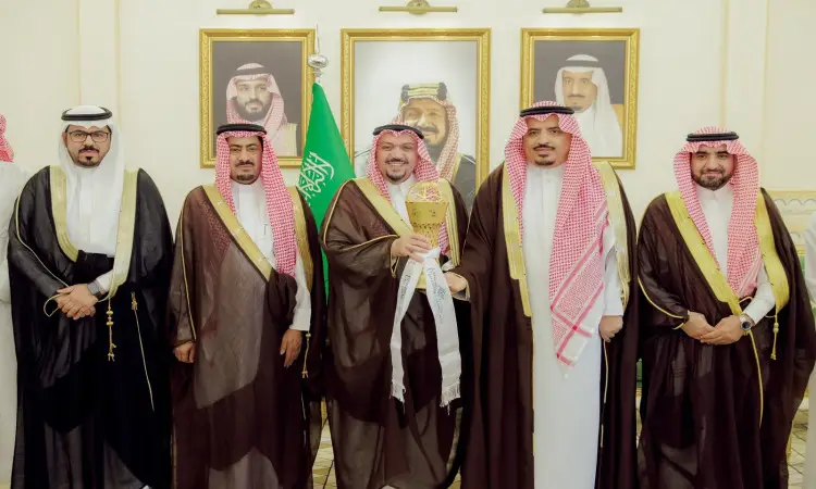 خمسة رجال تولى البشتاء السعودي والغترة أو الشماغ والعقال الاتصالون معاً في صورة الرجال، حيث عصر أحدهم كأساً ذهبية تكريماً لإنجاز منتخب جامعة القصيم لكرة القدم ضمن بطولة الاتحاد الرياضي. خلفهم علم المملكة العربية السعودية وثلاث لوحات مؤطرة لقيادات الوطن معلقة على الحائط.