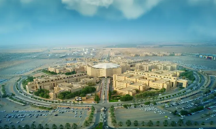 منظر جوي لجامعة القصيم، وهو الحرم الجامعي الواسع الذي يضم العديد من المباني المخصصة للأشجار الخضراء ومواقف السيارات. يحتضن فريق الحرم باحثاً متميزاً اختلافاً نوعاً جديداً من سوسة النخيل الأحمر، حيث يظهر بعض أعضاء الفريق وهم كذبت الغترة أو الشماغ والعقال وكذلك البشت السعودي، ما يعكس التوقيع الرسمي الأصيلة للجامعة. للبحث عن الصحراء وتزين السماء الزرقاء الغيوم المتفرقة في دلالة أصالة المكان وريادة البحث العلمي في الجامعة.