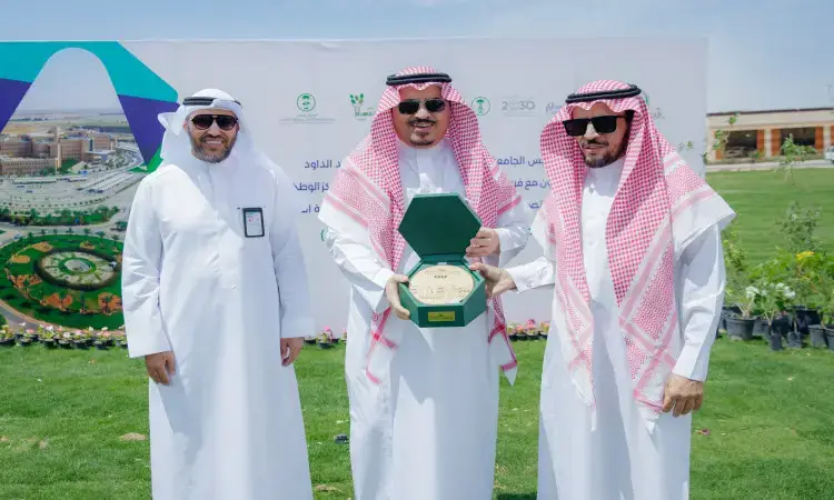 الاتصال ثلاثة رجال مرتدين الغترة أو الشماغ والعقال، وتتميز برأس الجامعة في المنتصف بارتدائه البشت السعودي ويحمل درعًا تكريمًا داخلها. لإعدادها خلفهم لوحة تحمل نصوصًا باللغة العربية من بالإضافة إلى "لنجعلها خضراء" وشعارات متعددة مع تنسيقات جمالية لافت للأزهار الملونة المزروعة في.