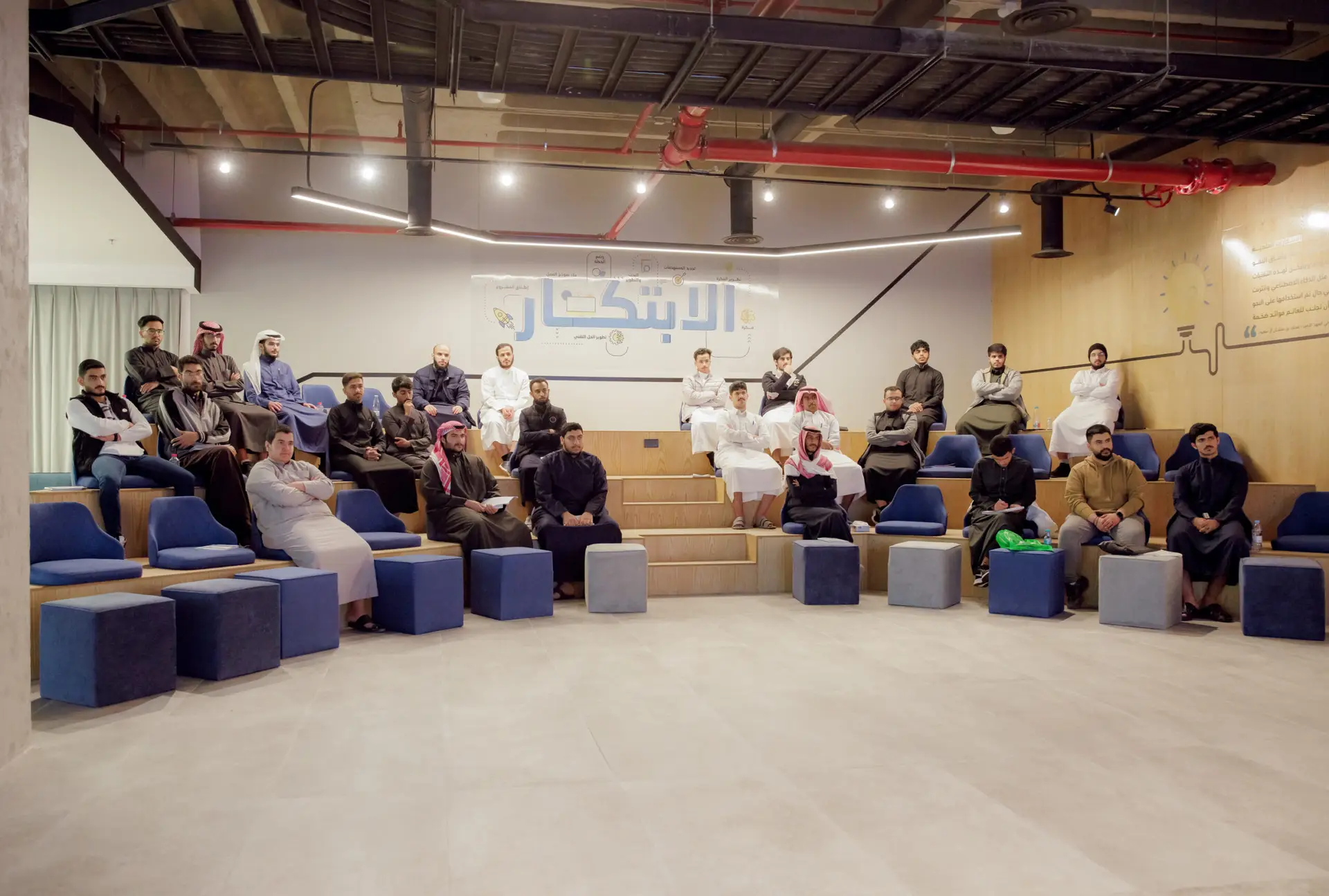 يجلس مجموعة من الأشخاص، ولا يظهرهم من الرجال الشماغية السعودية التقليدية، على مساحة حديثة إلا بلمسات خشبية وكتابات عربية على الجدران، وهي مناطق جذابة في القصيم وتدعو الزوار إلى اكتشاف المنطقة.