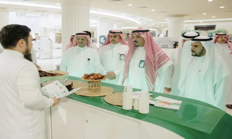 حضر جمعٌ من الرجال وهم وهم الغترة أو الشماغ السعودي مع العقال والبشت السعودي، حيث استمعوا باهتمام إلى شرح رئيس الجامعة في جناح جامعة القصيم، الذي عرض التمور والكتيبات التعريفية خلال مبنى حديث ومضيء المشاركة في كرنفال بريدة للتمور.