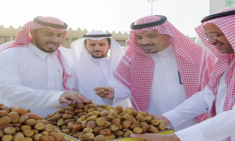 كل الرجال مرتدين البشت السعودي والعقال مع الشماغ والغترة السعودية، لكم دون اربعة موضوعًا في الصلصة الكبيرة خلال فعاليات كرنفال بريدة للتمور. لرعاية خلفهم مباني بالقرب من جناح جامعة القصيم، وذلك بحضور معالي رئيس الجامعة.