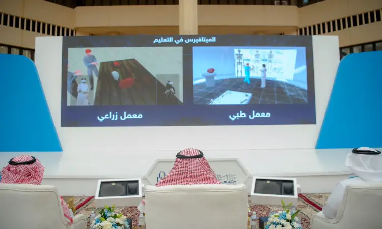 يجلس أربعة رجال تحت الغترة أو الشماغ السعودي مع العقال والبشت السعودي، إلى جانب رئيس الجامعة، مقابل شاشة كبيرة تعرض محاكاة الواقع الافتراضي لعامل الطب الزراعي باللغة العربية، وذلك من خلال مؤتمر يوم التوعية بالتحول الرقمي الحديث في جامعة القصيم.