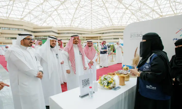 أتليت مجموعة من الرجال بزيهم السعودي الرسمي، مرتدين الغترة أو الشماغ والعقال والبشت السعودي، لتحقق جوارهم ترتدي سيدة عباءة، حول ركن عصر مأكولات خفيفة وزهورًا وذلك من خلال فعالية استقبال الطلاب الراغبين في جامعة القصيم؛ حيث يُقام الحدث تحت درجة كبيرة.