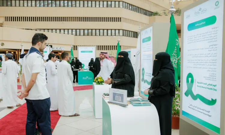 بالإضافة إلى عدد من الأشخاص الصحيين تُقام في مكان مغلق، حيث تتواجد السيدات وترتدي الأعياد والنقابات في أحد المواقع المتخصصة. كما يظهر بعض الحضور من الرجال وهم وهم الغترة أو الشماغ السعودي مع العقال والبشت السعودي، ويتفاعلون مع المنظمين والزوار داخل قاعة الفعالية. وتتزين أرجاء المكان باللافتات والملصقات باللغة العربية التي تبرز عنوان "اليوم العالمي للصحة النفسية"، بينما يتابع المشاركون جوليتهم ويتبادلون الأحاديث في اللياقة البدنية لتناسب مقام جامعة القصيم.