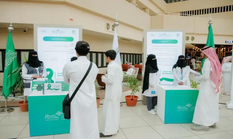 يتفاعل عدد من الأشخاص مرتدين الغترة أو الشماغ والعقال والبشت السعودي في أروقة قاعة حديثة في القصيم، حيث اتصلون عند محددات تعريفية توصل وتوصل وملصقات توعوية حول صحة الصحة النفسية، ويبرز في المكان الأخضر وجود كشكين تزينهما أعلام المملكة وشعارات الجامعة.