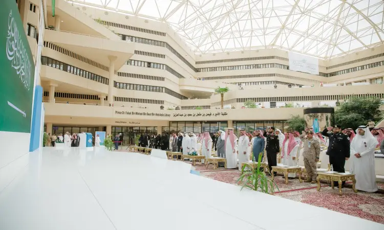 The event is held at Qassim University, where participants can be seen on the red carpet wearing the Saudi Ghutra or Shemagh with the Saudi Aqal and Bisht, along with the presence of uniformed elements. The venue is characterized by its multifaceted and glass roof, and the banners of Nazaha Faith Clubs are dotted with the spirit of integrity and national belonging.
