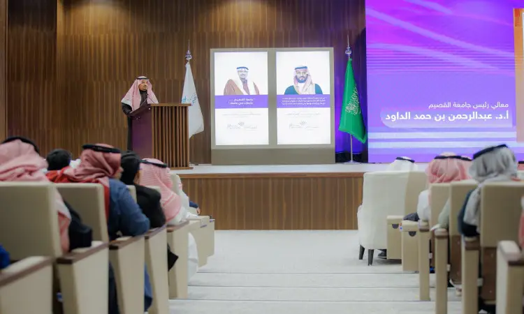 الطامع الحضور في قاعة محاضرات في القصيم مرتدياً الغترة والعقال والبشت السعودي. خلف الجلوس صورتان الاول والثاني بارزتين مع نص عربي وعلم المملكة العربية السعودية يرفرف بجانبهما. احتراما للأكاديمية الرسمية للاهتمام بالجامعة بتكريم إنجازات الطلاب، فيما يتعلق بالحضور بملابسهم التقليدية باحترام واهتمام.