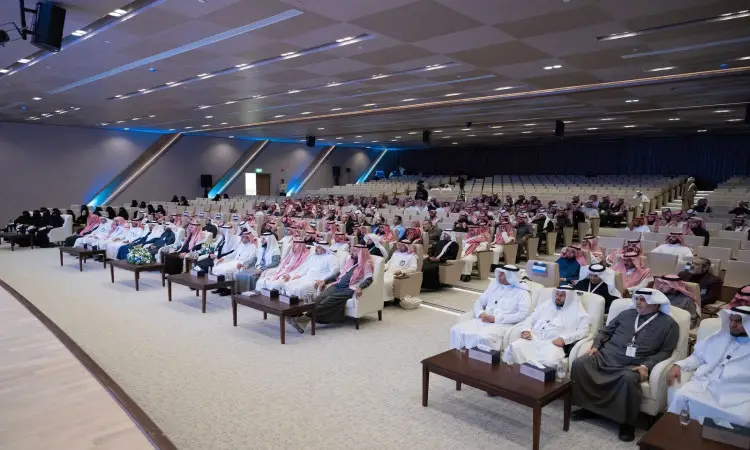 قاعة مؤتمرات واسعة امتلأت بالحضور، غالبيتها من الرجال مرتدين الغترة أو الشماغ السعودي مع المقالات، بالإضافة إلى فيديوهات للشتاء السعودي الأساسي. يجلس أعضاء اللجنة في مقاعدهم من أجل أصوات مخصصة حسب اللون، يجهزون جميع المقاعد المخصصة لفعاليات "الملتقى الأول في التعليم العالمي" في القصيم. كما تواجد عدد من في القاعة، يجلسون في الصفوف الخلفية معترفين بالطابعة الرسمية للفعالية.