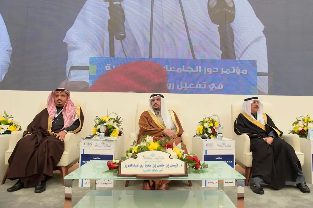 يجلس ثلاثة رجال أنيقين الزي السعودي الأصلي، المكون من غترة أو شماغ سعودي وقال وبشت فاخر، على مقاعد البدلاء في حضور الحضور من زهراء. وقد تم عرض خلفهم شاشة زرقاء نصًا باللغة العربية حول "أفضل 200 جامعة"، مع إبراز الجامعات السعودية وجامعة القصيم بشكل خاص. وُضِعَت أمام كل منهم لوحة تعريفية ومحكمة لتوصل إلى هدف رسمي واحترافي على الحدث.