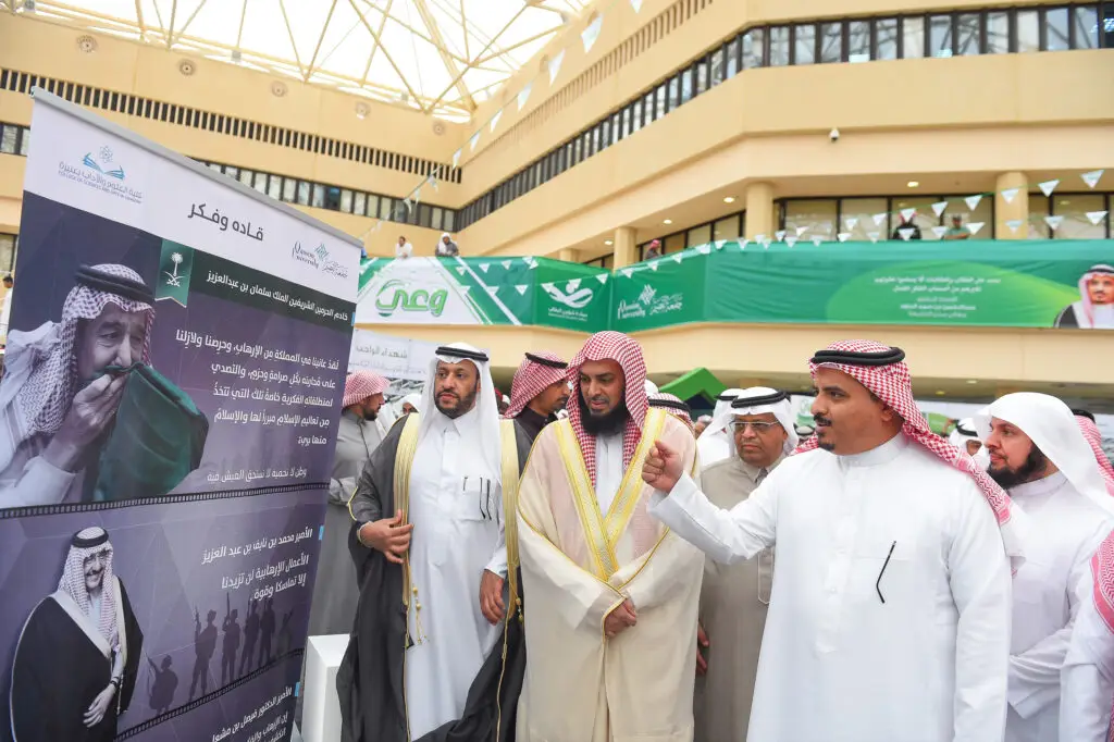 وقف جمعٌ من الرجال عذراء الغترة أو الشماغ السعودي الداخلي مع العقال والبشت السعودي في قاعة مضاءة بضوء السماء عبر الزجاج السقفي، يتأملون لوحة تحمل صورة خادمة الحرمين الشريفين الملك سلمان بن عبدالعزيز آل سعود، وسط أعلام المملكة العربية السعودية والرايات الخضراء، في تجسيدٍ بضايا حقوق الوطنية والوحدة التي تعتز بها جامعة القصيم.
