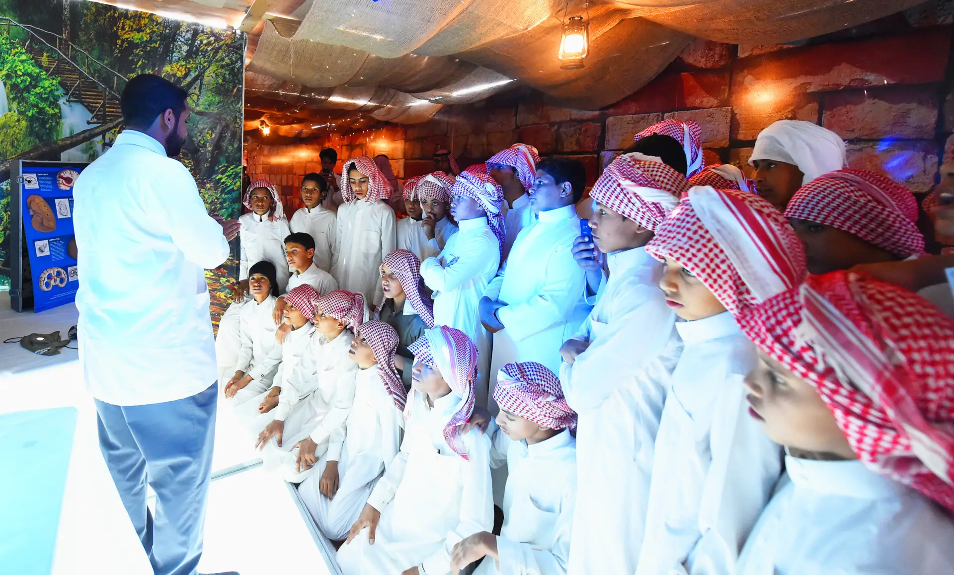 Dressed in white, a group of young men have gathered in the traditional Saudi shemagh and headband, while the Saudi Ghutrah is a beautiful favorite complement. These young people are listening intently to a man in a Saudi bisht as he talks about mental disorders, in a very funny and decorative hall in the hallways of Qassim University. The audience, standing and kneeling on the floor, are all listening and keeping their focus in the direction of the talk.