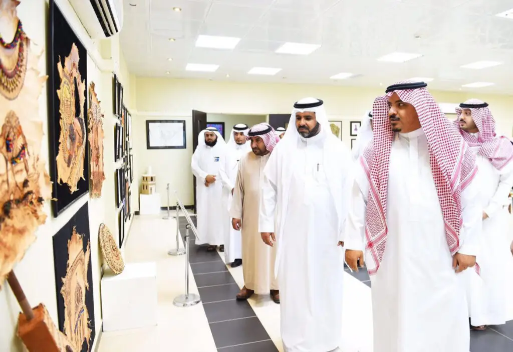 وتشاهد مجموعة من الرجال مرتدين الغترة أو الشماغ السعودي مع العقال والشت السعودي، والأعمال الفنية حتى تنتهي إلى إحدى قاعات المعارض المضاءة بشكل جيد في جامعة القصيم. وقد تمتلك بعض هذه التصميمات ونقوشات عسكرية دقيقة من رؤية 2030.