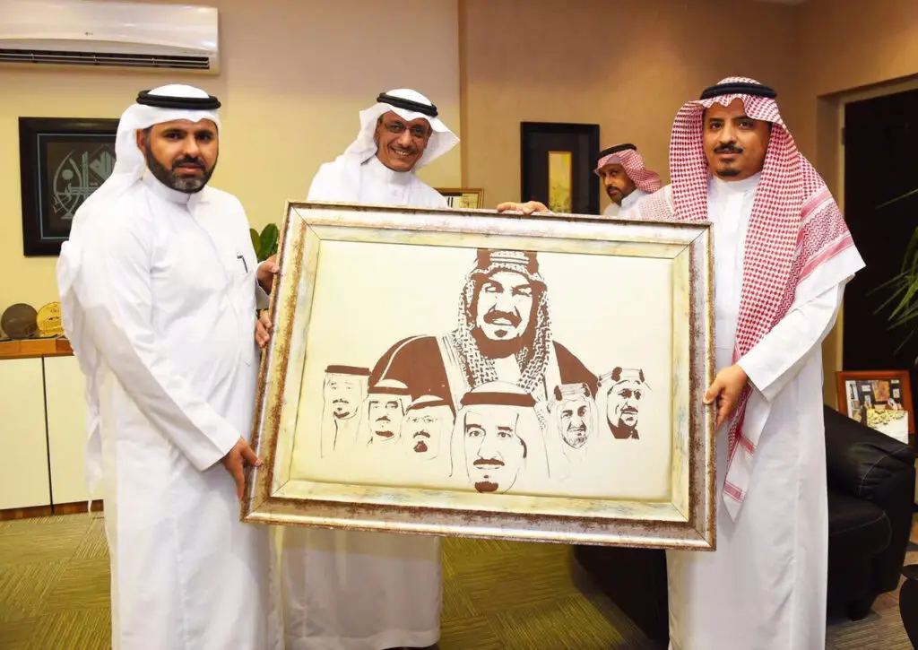 رجال تألقوا بالبشت السعودي والغترة أو الشماغ والعقال، الاتصالون في أربعة مكان مغلق مبتسمين، واثنين منهم بحمل عمل فني مؤطر يبرز صور بما في المملكة العربية السعودية، وذلك من خلال معرض "موضة فن" الذي نظمته كلية التصاميم والمنزل في القصيم.