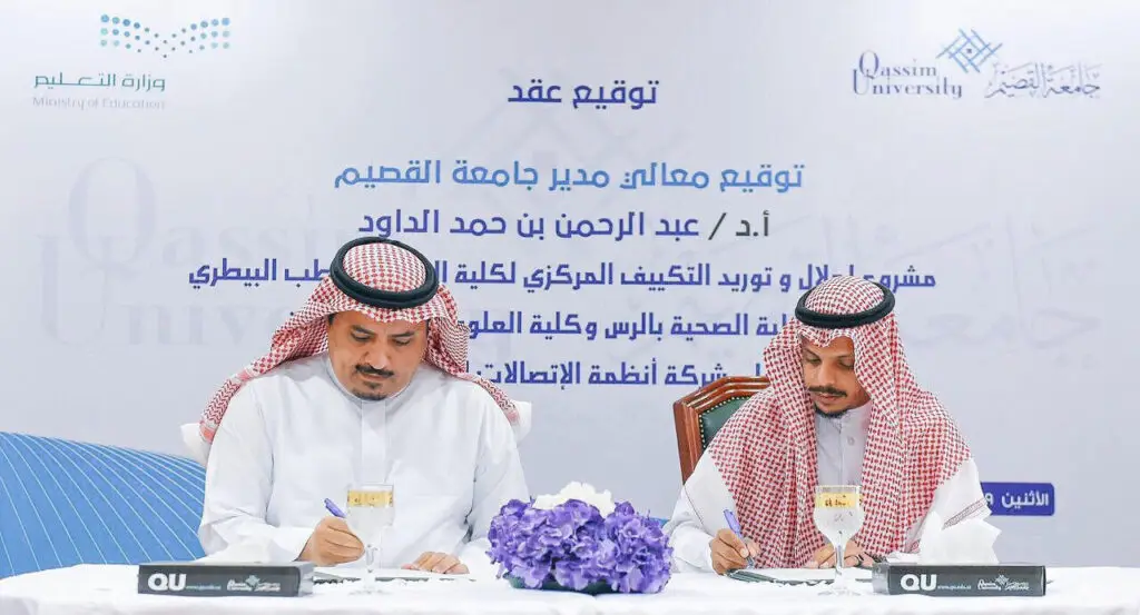 يرتدي الرجلان الزي السعودي الرسمي، المشاهير الغترة أو الشماغ والعقال بالإضافة إلى البشت السعودي، إلى طاولة حيث يقوم بتوقيع المستندات. لرعاية خلفهم خلفية تحمل شعار جامعة القصيم ووزارة التعليم، في إطار جهود تطوير إشارة الجامعة. وتزين باقة الزهور المزخرفة بشكل خاص بالزهور الرسمية.