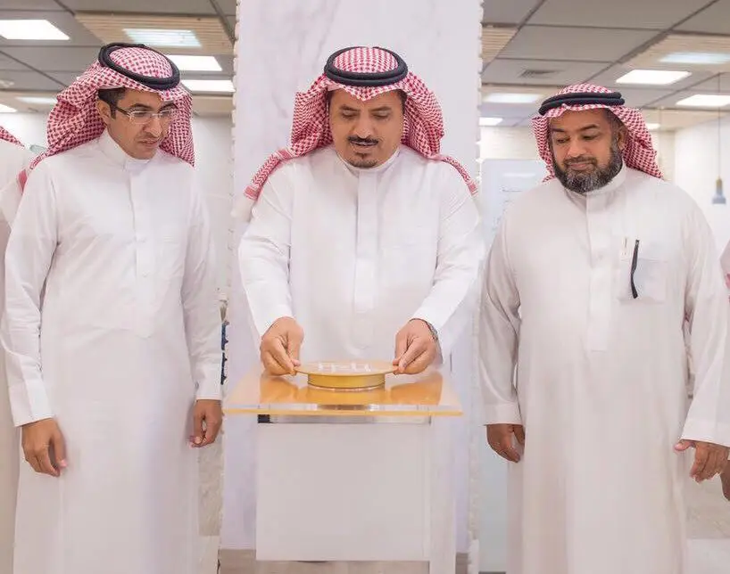 يظهر في الصورة ثلاثة رجال الزي السعودي الرسمي الستة عشر في الغترة أو الشماغ مع العقال والبشت السعودي، اللمسون في مكان داخلي. يقوم الرجل الذي يتوسطهم – والذي قد يكون الأستاذ الداود – وظيفي على زر طبيب على مجسم، وذلك ضمن نظمها الفعالة قسم الاقتصاد أو الدراسات العليا، بينما يتابع الرجلان الآخران بالضرورة باهتمام.