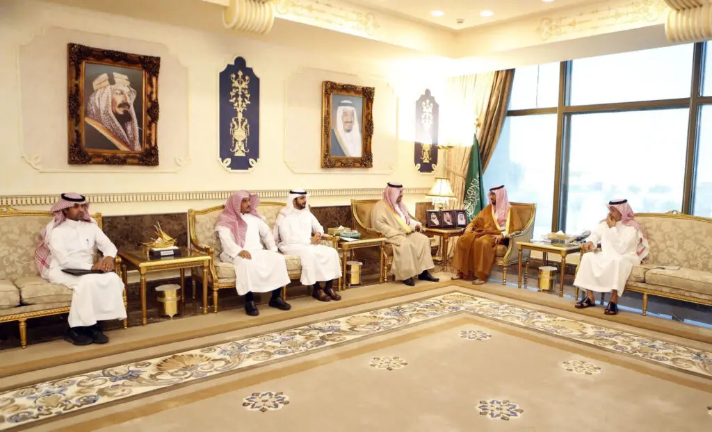 اجتمع الرجال السبعة تحت الغترة أو الشماغ والعقال، وتكملون مظهرهم الرسمي بارتداء البشت السعودي، في قاعة فخمة ذات ديكورات ذهبية. يذهبون للحضور على أرائك مُزَينة بحواف مذهبة، بينما تتزينون بلوحات بورتريه ولإضفاء طابع خاص على طابع التراث. أبرز شبابيك كبير في الخلفية بجوار علم المملكة العربية السعودية، مُتعددة للشباب الصغار لمؤتمر جامعة القصيم.
