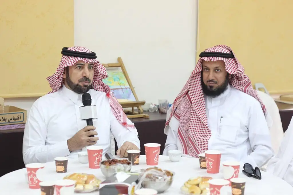 يجلس رجلان ويرتدي الزي السعودي التقليدي الامتداد في الغترة أو الشماغ والعقال، بالإضافة إلى البشت السعودي، حول طاولة مستديرة عليها مجموعة من المعجنات، بينما يضطر إلى الميكروفون. يجب أن نفكر في أدوات تفصيلية فنية ورسومات تبرز جانبًا من البرامج المجتمعية لكلية العلوم التطبيقية في الرس – جامعة القصيم.