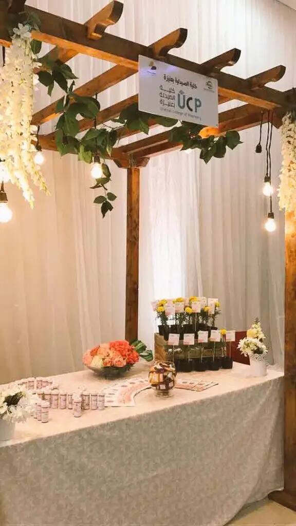 ويظهر جناح خشبي مُزخرف مزدان بمصابيح معلّقة وزهور بيضاء، ويعرض على أكل مغطاة بقماش أبيض مجموعة من الجرار والحاويات الصغيرة ونباتات مزروعة. والعديد من اللحوم المصنعة مع لمسات تراثية سعودية مميزة؛ إذ تتدل شماعات تحمل شماغاً سعوديًا وتترةً، إذ يزين العقال أحد أركان الجناح وتنسدل على امتصاصها بشت سعودي أصيلة. ويتصدر شعارنا الوطني لجامعة القصيم والأسبوع العالمي للتوعية بالمضادات الحيوية مكتوبًا باللغة العربية برقم الهوية الوطنية للجامعة.