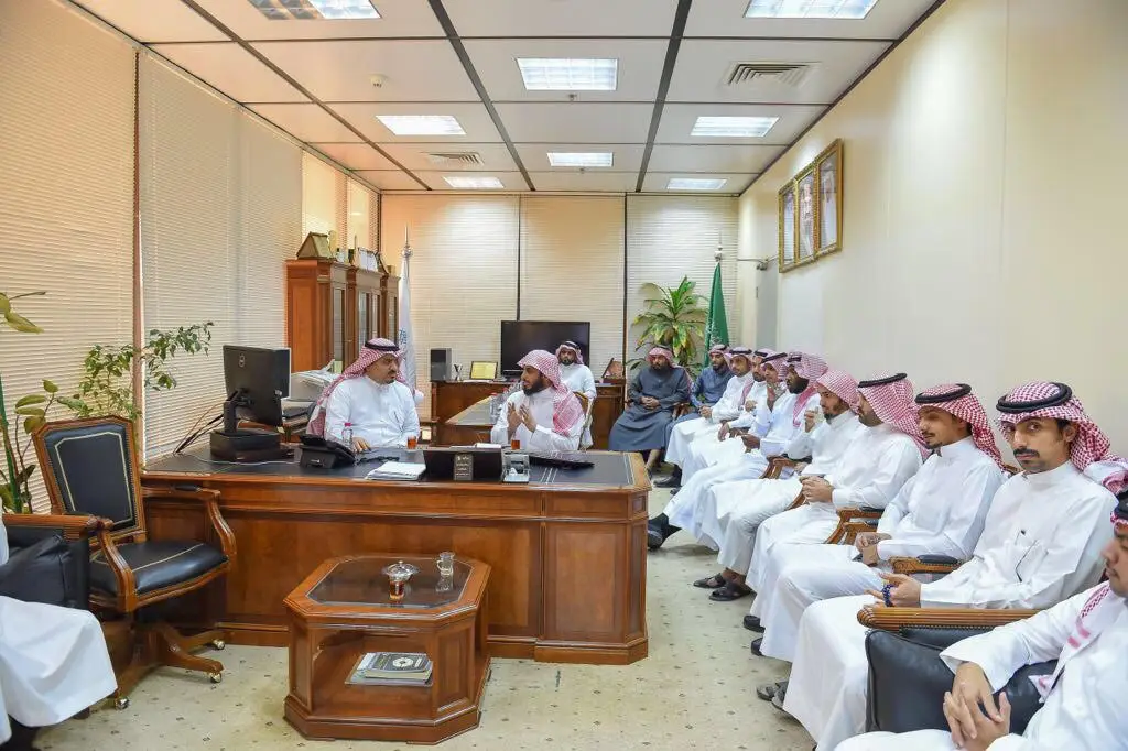 يجتمع مجموعة من الرجال مرتدين الغترة والشماع والعقال والبشت السعودي في أحد الطلاب، حيث ينضمون إلى مدير الجامعة. يناقشون حول مكتب سكوت بينما يناقشون بأصواتهم الجدار، ويناقشون حول سير العمل. ويتميز المكتب بصور معلقة على الجدران، ونباتات خضراء موزعة في الجناح، بالإضافة إلى إضاءة فلورية الثقة لوجود تلفيق في القصيم.