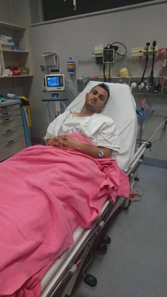 He lies in the hospital, wearing a hospital gown, with a pink bed wrapped around him. He is surrounded by medical equipment and monitors in the room, following the persistent efforts to save the expatriate in Melbourne. It is noteworthy that the man wore a Saudi shemagh with a headband and a Saudi bisht while he was out of treatment, in line with his official representation of Qassim University.