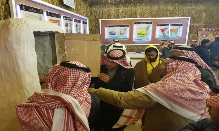 مجموعة من الرجال غير مدمرة الغترة أو الشماغ والعقال، ويكتسون بالبشتت داخل السعودي، تكفيدون عرضاً أحد أروقة المتحف أو جناح معرض ثقافي في القصيم، تضررت بملصقات ولوحات معلوماتية تسلط الضوء على مهرجان الجنادرية الثقافية والأنشطة المصاحبة له.
