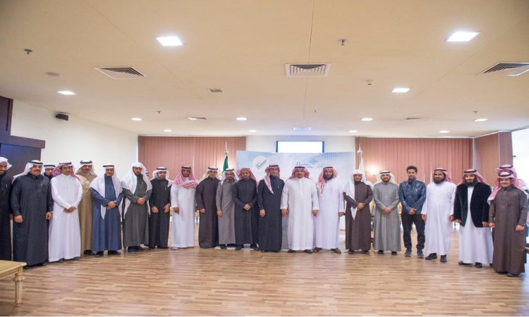 يصطف مجموعة من الرجال الحضور الغترة أو الشماغ السعودي مع العقال، وبعضهم يرتدون البشتاء السعودي، إلى جانب ملابس الزفاف الحديثة، داخل قاعة ملابس خشبية. يتوسطهم معالي مدير جامعة القصيم وتواجد خلفهم راية المملكة العربية السعودية، حيث تم التقاط الصورة الأكاديمية بعد توقيع عددٍ من الأشخاص الرسميين.